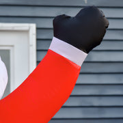 Close-up of the Santa black mitten and red sleeve against a grey wall