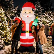 Friends taking a selfie with the lit Santa at a night-time Christmas market
