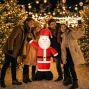 Four friends taking a selfie with the lit Santa at a Christmas market at night
