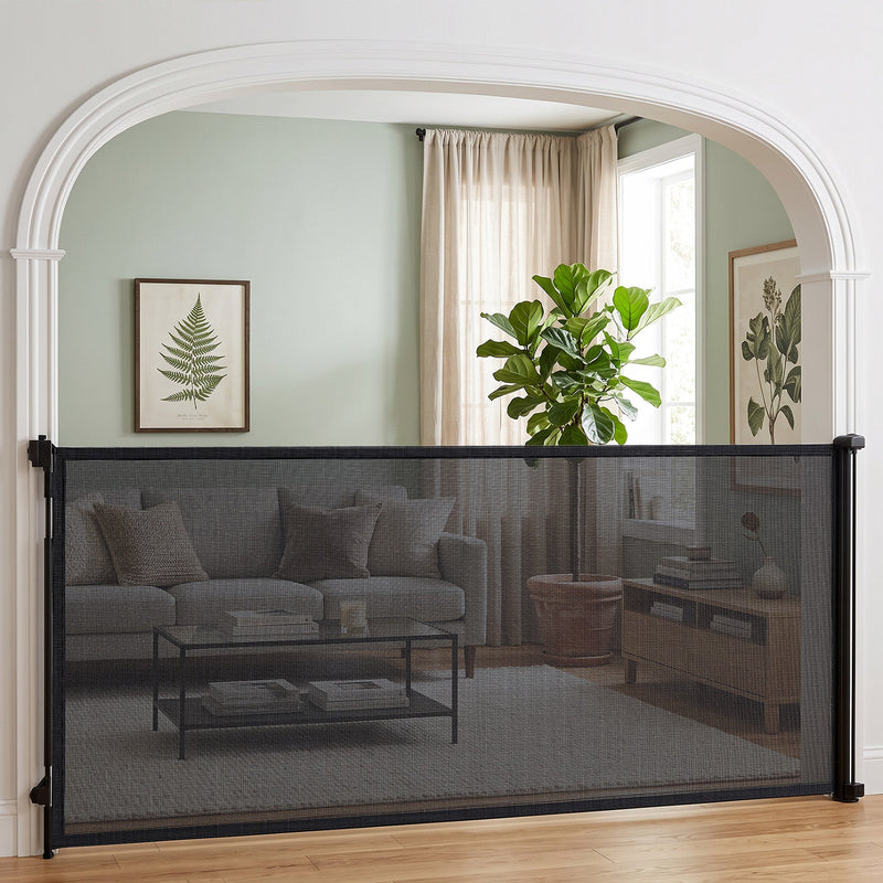 Black retractable dog gate across an arched doorway to a living room