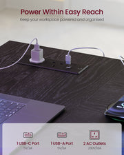 Close-up of the desk's built-in power strip with two AC outlets, a USB-A port and a USB-C port