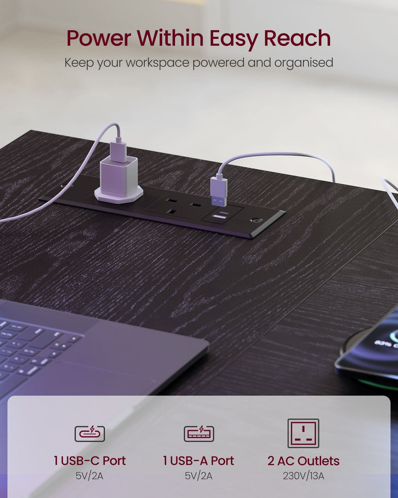 Close-up of the desk's built-in power strip with two AC outlets, a USB-A port and a USB-C port
