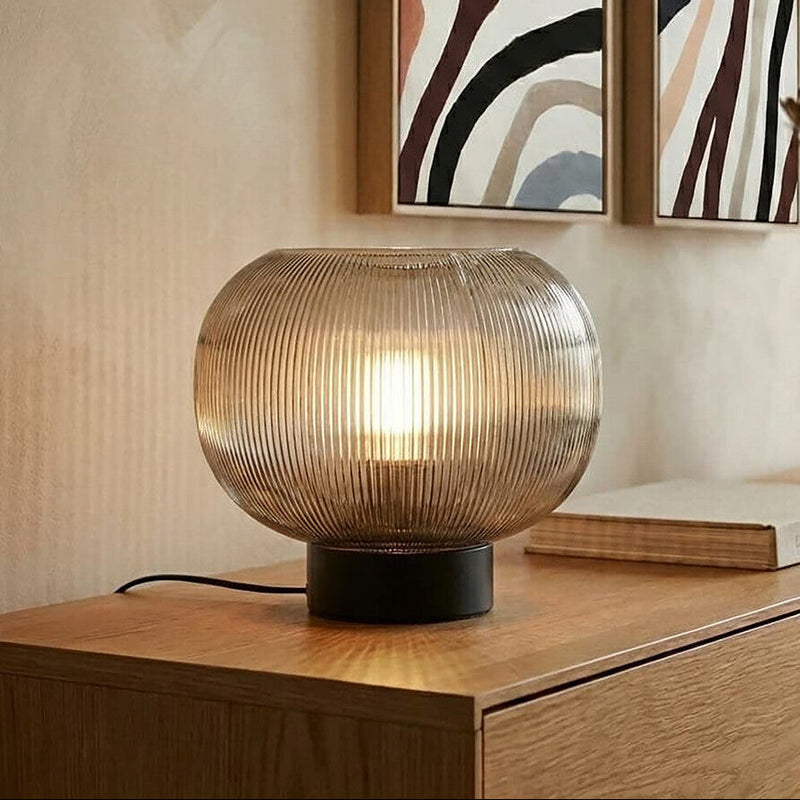 Ribbed smoked brown glass globe table lamp on a console table