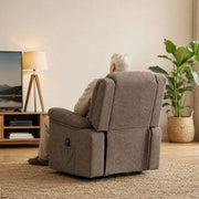 Man relaxing in the riser recliner seen from behind in a bright living room