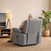 Rear view of a man seated in the recliner facing a TV, with the side pocket visible