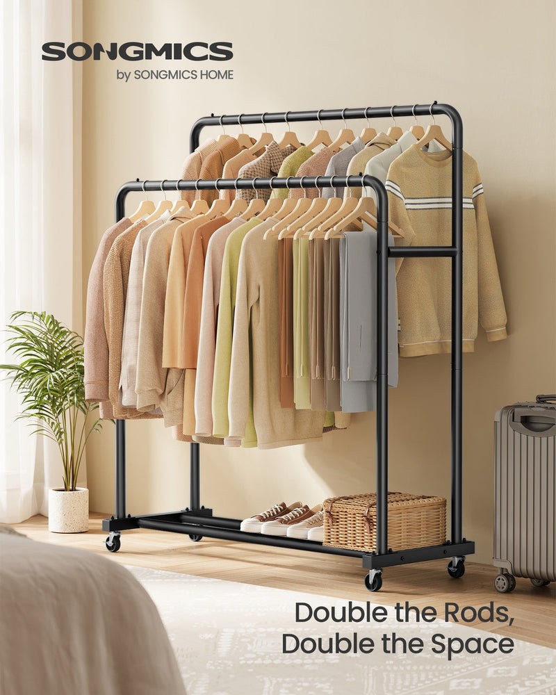 Ink black double rod clothes rack styled in a bedroom with hanging jumpers and a suitcase nearby