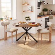 Round dining table set for breakfast in a bright kitchen with two chairs