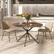 Round dining table with two beige chairs in a modern kitchen with a marble splashback