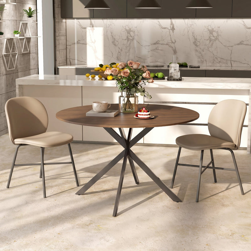Round dining table with two chairs in a modern kitchen with a marble splashback