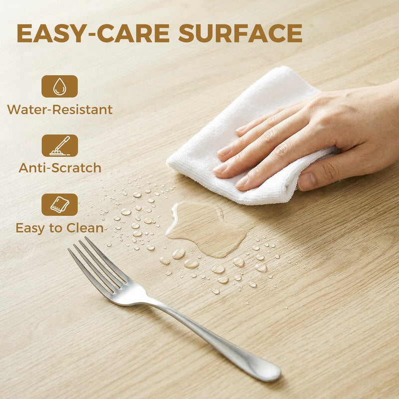 Close-up of a hand wiping the wood effect tabletop with water droplets and a fork beside it