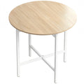 Round folding dining table with natural wood effect top and white steel X-frame legs on a white background