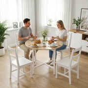 Couple eating breakfast at the round folding table with white chairs in a bright dining room