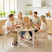 Group of four eating at the round folding table next to a kitchen worktop
