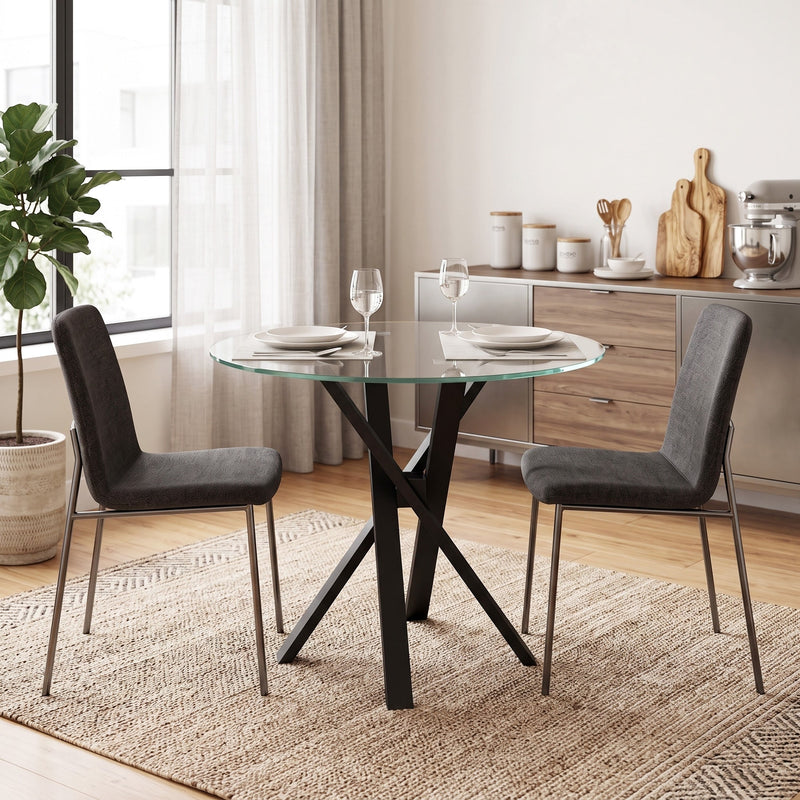 Glass dining table with dark grey chairs on a woven rug
