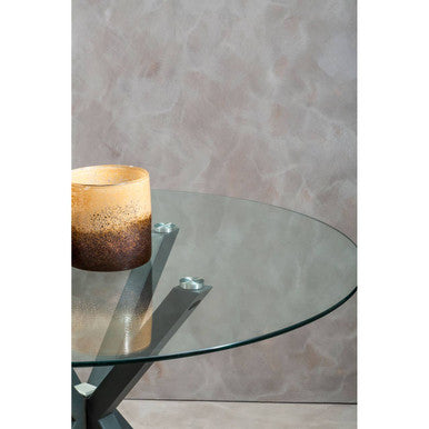 Round glass dining table with grey metal legs, studio shot