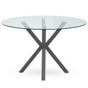 Round glass dining table with grey metal legs, studio shot