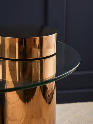 Pair of rose gold glass side tables placed at either end of a sofa