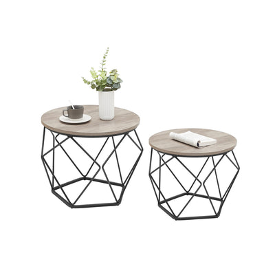 Studio product shot of the Vasagle set of 2 round nesting coffee tables with a vase, coffee cup and book on top