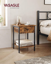 Bedside table styled with a lamp and cup next to a black metal bed frame
