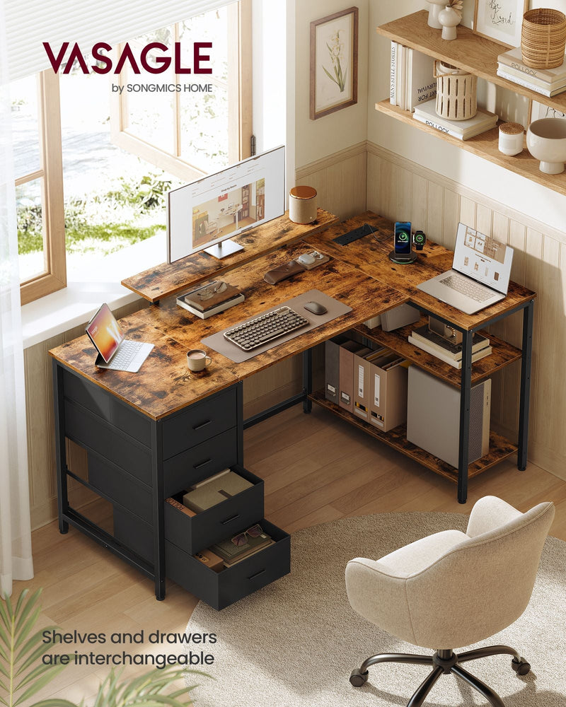 Top-down view of the L-shaped desk in a bright corner with a monitor, laptop and armchair