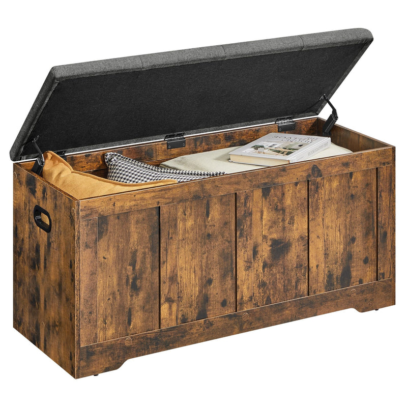 Rustic brown storage bench with the grey cushioned lid open, holding a blanket and books