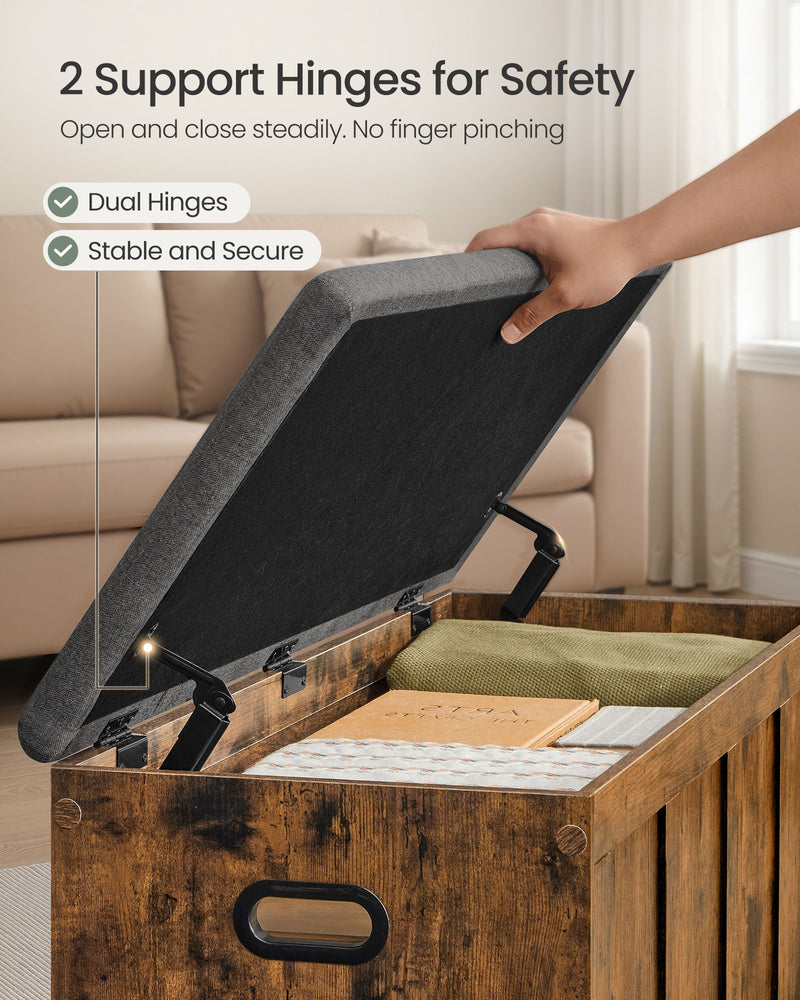 Hand lifting the cushioned lid on the storage bench, showing the dual safety hinges