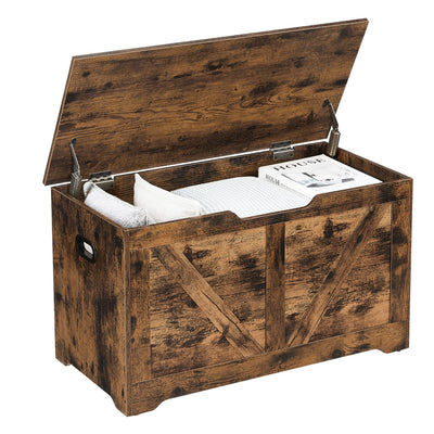 Rustic brown Vasagle storage chest with lid open showing blankets, pillows and a magazine inside
