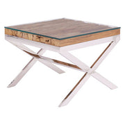Natural wood and glass top side table with polished steel X-frame on a plain background