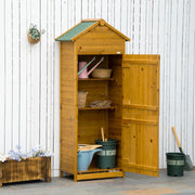 Wooden tool shed against a white fence with the door open showing shelves and plant pots