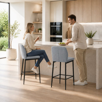 Couple seated on grey velvet bar stools at a kitchen island