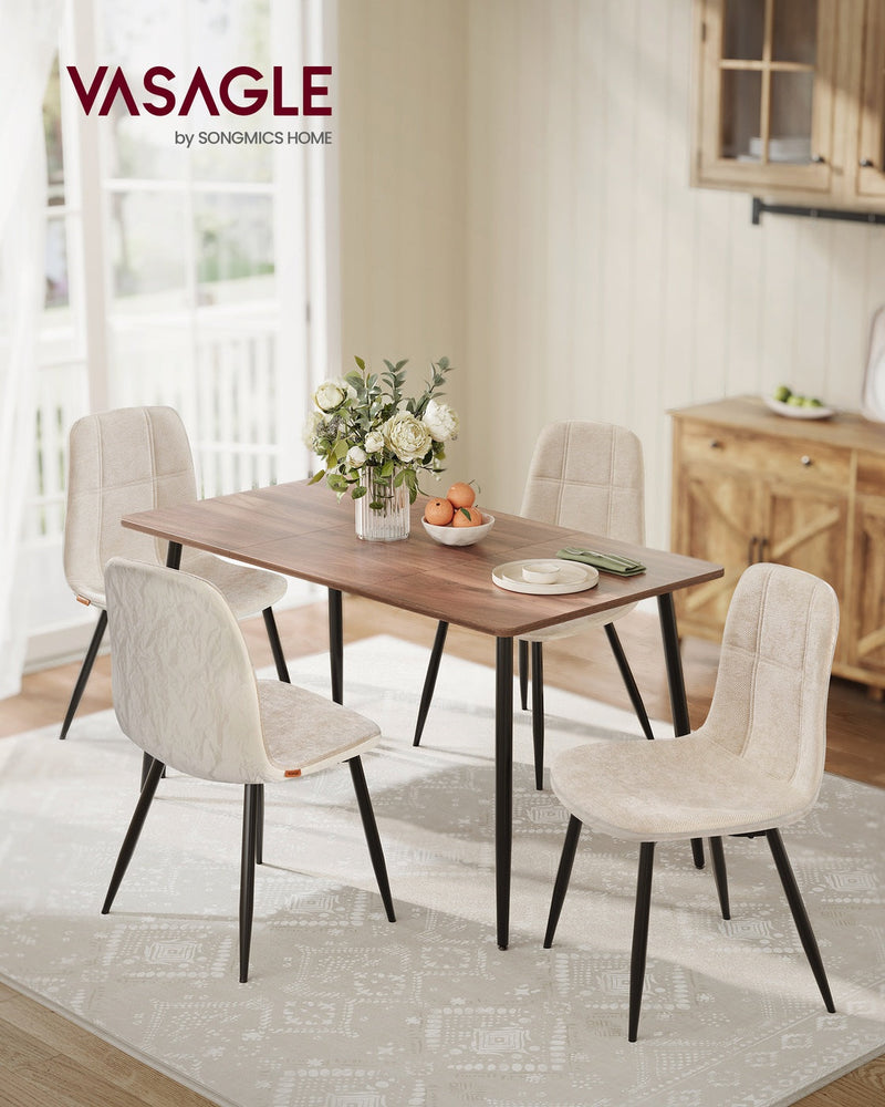 4 cream white dining chairs around a wooden dining table in a bright dining room
