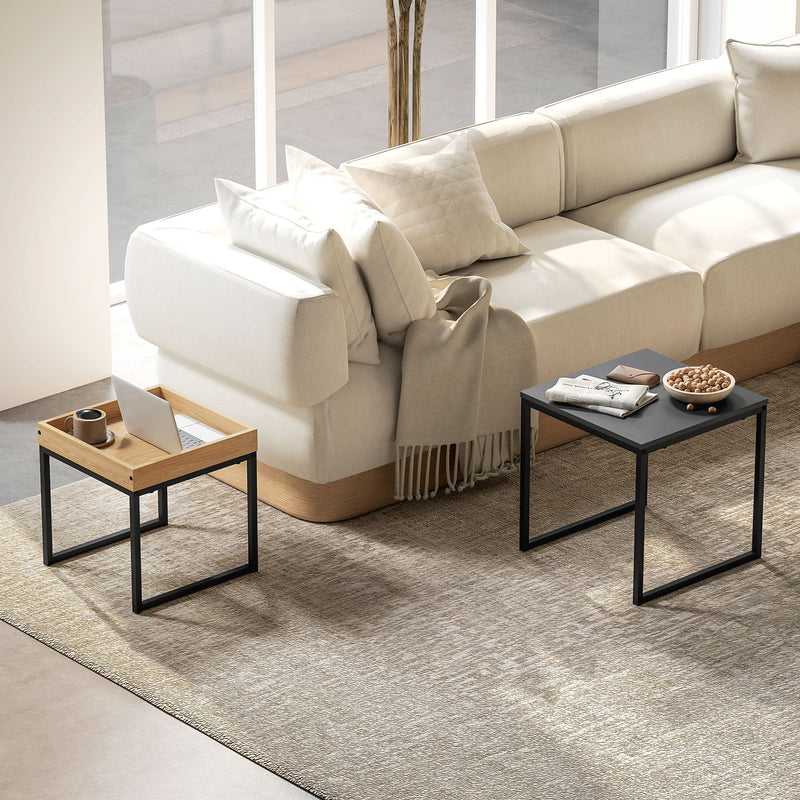Black and wood-effect nesting tables used separately either side of a sofa