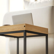 Close-up of the wood-effect tray tabletop corner with a laptop resting on top