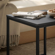 Close-up of the black tabletop with a newspaper and glasses resting on top