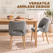 Armless grey dining chairs tucked under a wooden table