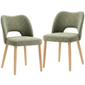 Two green chenille dining chairs with natural rubberwood legs on a white background