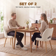 Couple eating at a wooden dining table with beige chenille chairs
