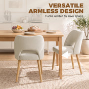 Armless beige dining chairs tucked under a wooden table