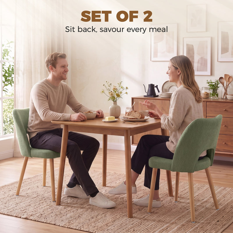 Couple eating at a wooden dining table with green chenille chairs