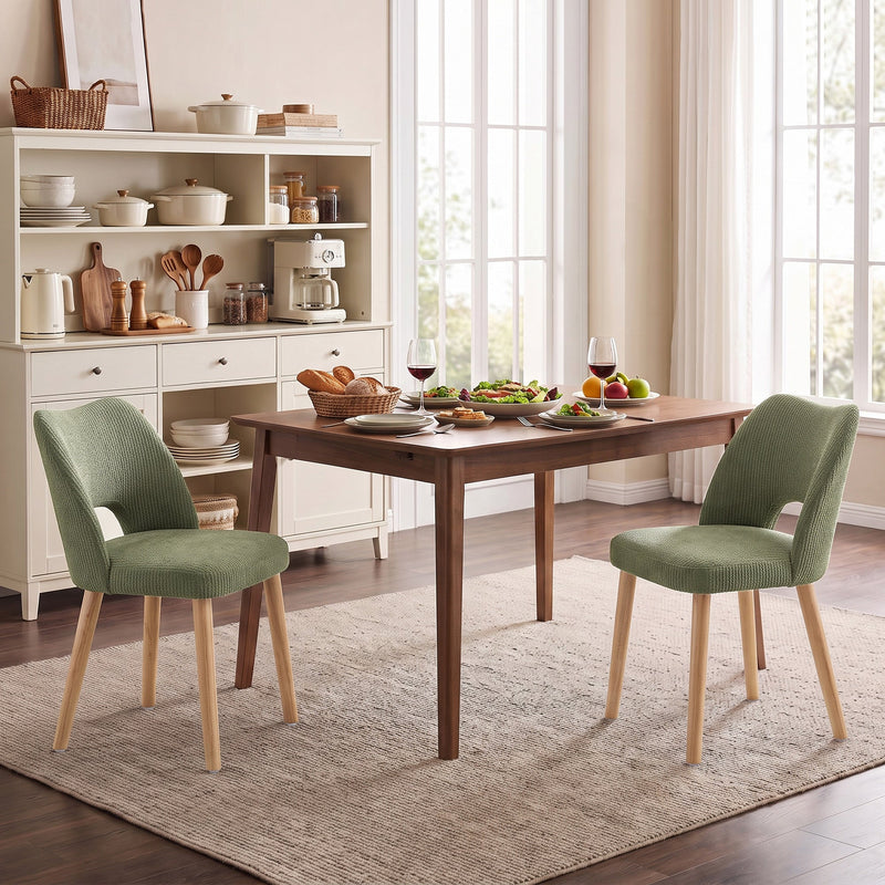 Two green dining chairs at a table in a kitchen diner