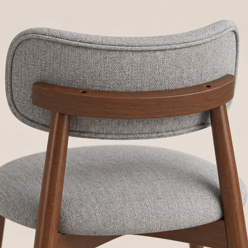 Close-up of the grey chenille seat and curved backrest on a wooden frame