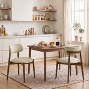 Two beige chenille dining chairs at a wooden kitchen table in a bright room