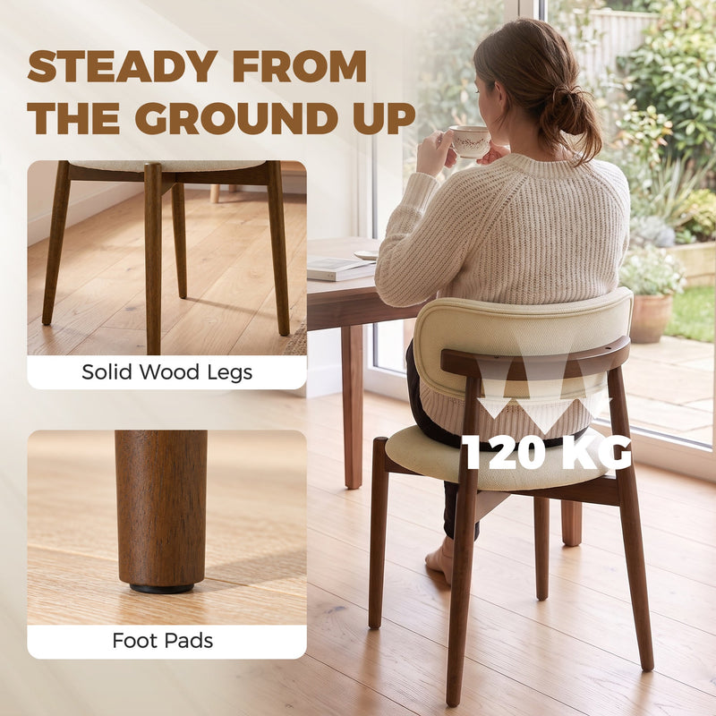 Woman sitting on a beige dining chair with solid wood legs, foot pads and a 120 kg weight label