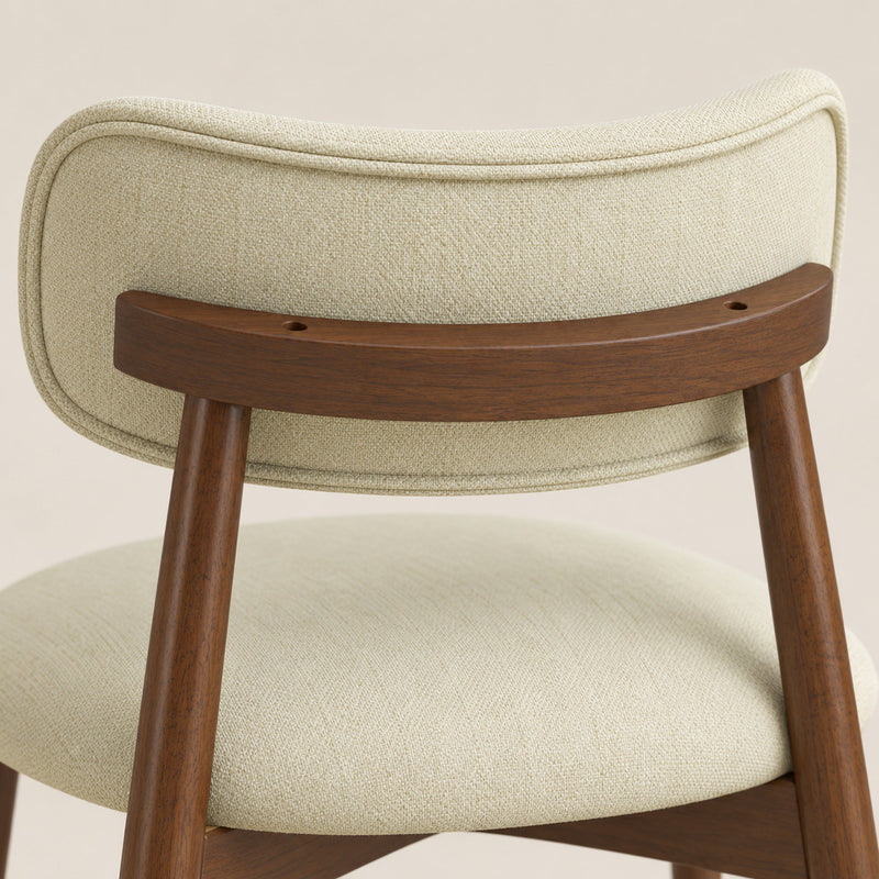 Close-up of the beige chenille seat and curved backrest on a wooden frame