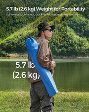 Person carrying the folded chair in its blue bag over one shoulder, noting the 2.6 kg weight