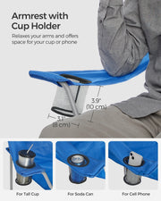 Close-up of the armrest cup holder shown holding a tall cup, a soda can and a mobile phone