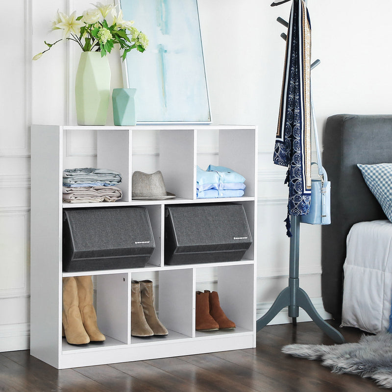 The two grey boxes side by side in a white shelving unit with clothes and boots