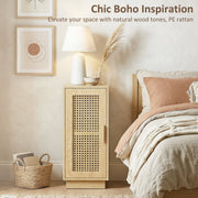 Bedside table with rattan door next to a bed with a lamp and plants