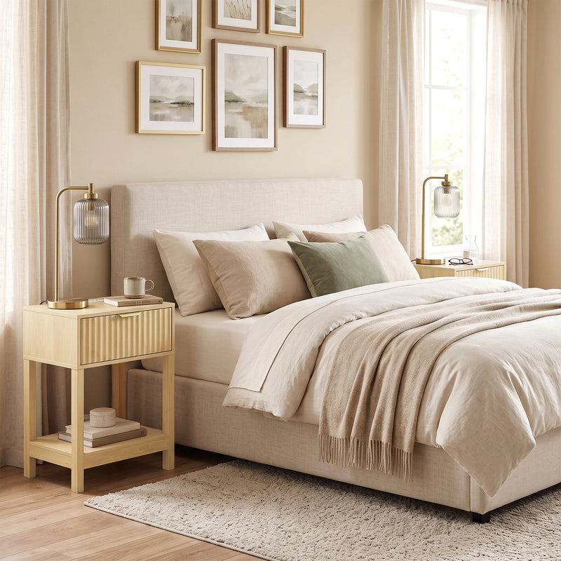 Oak fluted bedside table beside a bed in a neutral bedroom