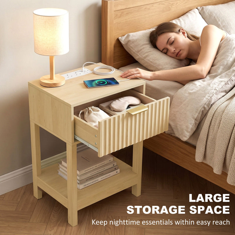 Person sleeping beside an oak bedside table with the drawer open and a lamp on top